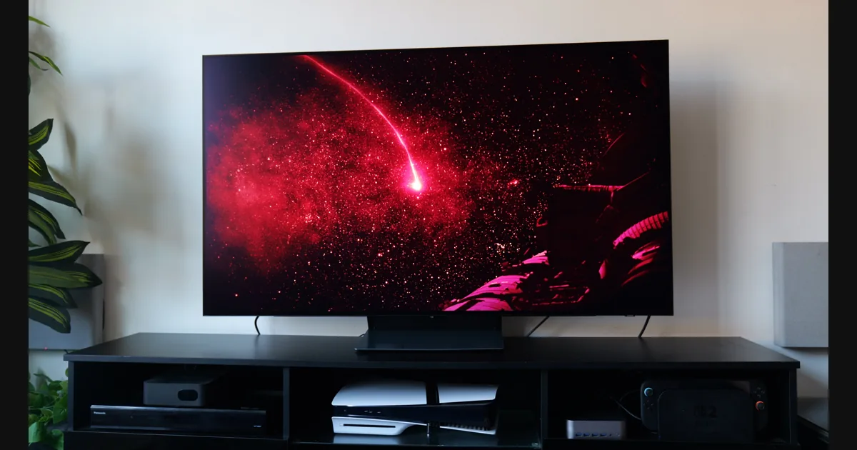 OLED-телевизор Samsung S90H в тёмной комнате с яркой игровой сценой