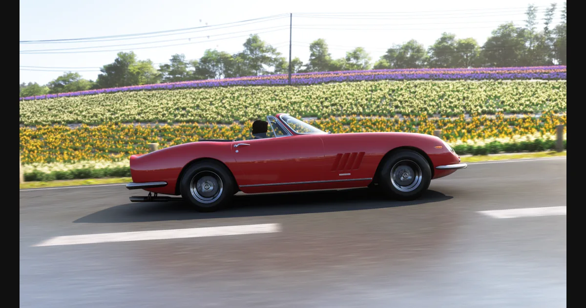 Красный спортивный автомобиль на пустой дороге